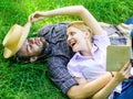 Couple soulmates at romantic date. Man and girl lay on grass relaxing. Couple in love spend leisure reading book