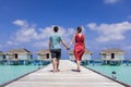 Couple spending romantic beach vacation holidays at luxurious resort in Maldives with overwater villas, turquoise sea water and Royalty Free Stock Photo