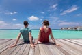 Couple spending romantic beach vacation holidays at luxurious resort in Maldives with turquoise sea water, blue sky and overwater Royalty Free Stock Photo