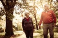 Couple in sports clothing walking trough park and having Royalty Free Stock Photo