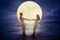 Couple standing on beach and watching the moon.Celebrate Mid autumn festival concept