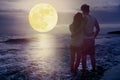 Couple standing on beach and watching the moon.Celebrate Mid autumn festival