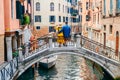 couple standing on the bridge crossing venice canals