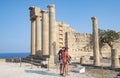 A Couple Standing in Front of the Ruin of Temple of Athena Reading a Plaque