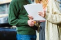 Couple standing holding paper keys.