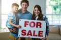 Couple standing and holding sold sign Royalty Free Stock Photo