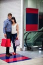 Couple standing near escalator in shopping mall Royalty Free Stock Photo