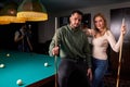 young caucasian beautiful couple standing near the pool billiard table Royalty Free Stock Photo