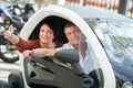 Couple standing near twizy electric