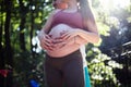 Couple standing in the park and touch the stomach Royalty Free Stock Photo