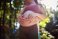 Couple standing in the park and touch the stomach Royalty Free Stock Photo