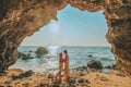 Couple standing on a rock at the cave entrance Look at the sea and beautiful views. at sunset romantic atmosphere at Kho Larn ,