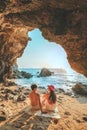 Couple standing on a rock at the cave entrance Look at the sea and beautiful views. at sunset romantic atmosphere at Kho Larn ,