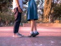 A couple standing together, legs and sneakers of couple in school uniform standing in the park, Symbol sign couple embracing
