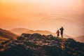 Couple standing on the top of the hill on the mountains meadow with beautiful colorful sunset over landscape Royalty Free Stock Photo