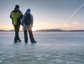 Couple stay on frozen lake and hold hands
