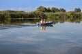 Couple with Straw Hats on a Small Motor Boat in the River