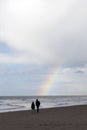 Couple strolls on north sea beach in holland with cloudy sky and Royalty Free Stock Photo