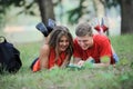 Couple of students lying on the grass in the Park and reading a book Royalty Free Stock Photo