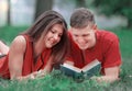 Couple of students lying on the grass in the Park and reading a book Royalty Free Stock Photo