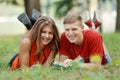 Couple of students lying on the grass in the Park and reading a book Royalty Free Stock Photo