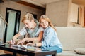 Couple students studying, reading book while sitting on sofa Royalty Free Stock Photo