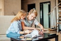 Couple students studying, reading book while sitting on sofa Royalty Free Stock Photo