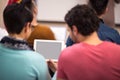 Couple of students watching tablet on lecture