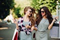 Couple of stylish girls after shopping with shopping bags.