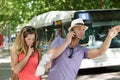 Couple in suburbs holding map and hailing bus Royalty Free Stock Photo