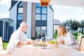 Couple of successful businessmen having breakfast on their summer terrace