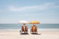 Couple sunbathing on the beach in summer, Thailand, rear view of a Retired traveling couple resting together on sun loungers