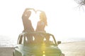 Couple at sundown on the beach with car Royalty Free Stock Photo