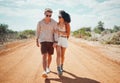 Couple, sunglasses and walking on dirt road in nature on holiday, vacation or summer safari trip. Diversity, love and