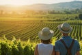 couple in sunhats, enjoying a sunlit vineyard view Royalty Free Stock Photo
