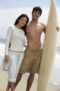 Couple With Surfboard On Beach