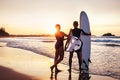 Couple surfers stay on sunset ocean beach