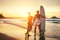 Couple surfers stay on sunset ocean beach