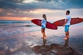 Couple of surfers walking on coast in Indonesia Royalty Free Stock Photo