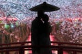 A couple sweetens in the dark on a bridge during cherry blossom season in Tokyo at the Meguro River, Japan Royalty Free Stock Photo