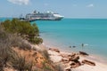 Couple swimming with dogs modern cruise ship tied up to jetty surrounded by a turquoise sea in the background at Broome in Western Royalty Free Stock Photo