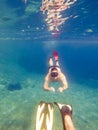 couple swimming underwater with mask and diving flippers