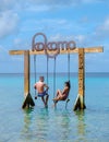 Couple at a swing in the ocean of Curacao Caribbean Island, Kokomo Beach Curacao Royalty Free Stock Photo