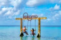 Couple at a swing in the ocean of Curacao Caribbean Island, Kokomo Beach Curacao Royalty Free Stock Photo