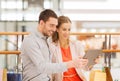 Couple with tablet pc and shopping bags in mall Royalty Free Stock Photo