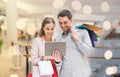 Couple with tablet pc and shopping bags in mall Royalty Free Stock Photo