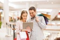 Couple with tablet pc and shopping bags in mall Royalty Free Stock Photo