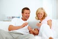 Couple, tablet and smile on sofa for social media, download funny movies and streaming internet show. Happy man, woman
