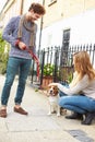 Couple Taking Dog For Walk On City Street Royalty Free Stock Photo
