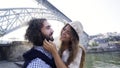 Couple taking funny selfie on embankment near bridge